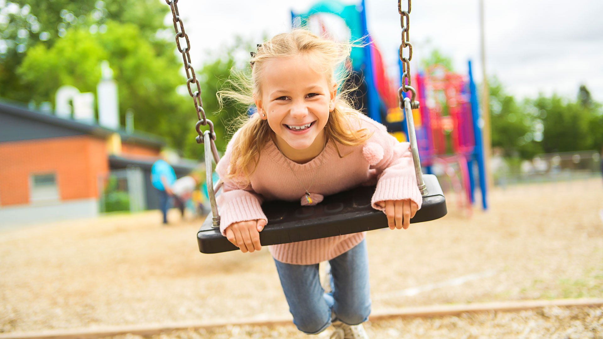 Ein Mädchen auf einer Schaulkel.